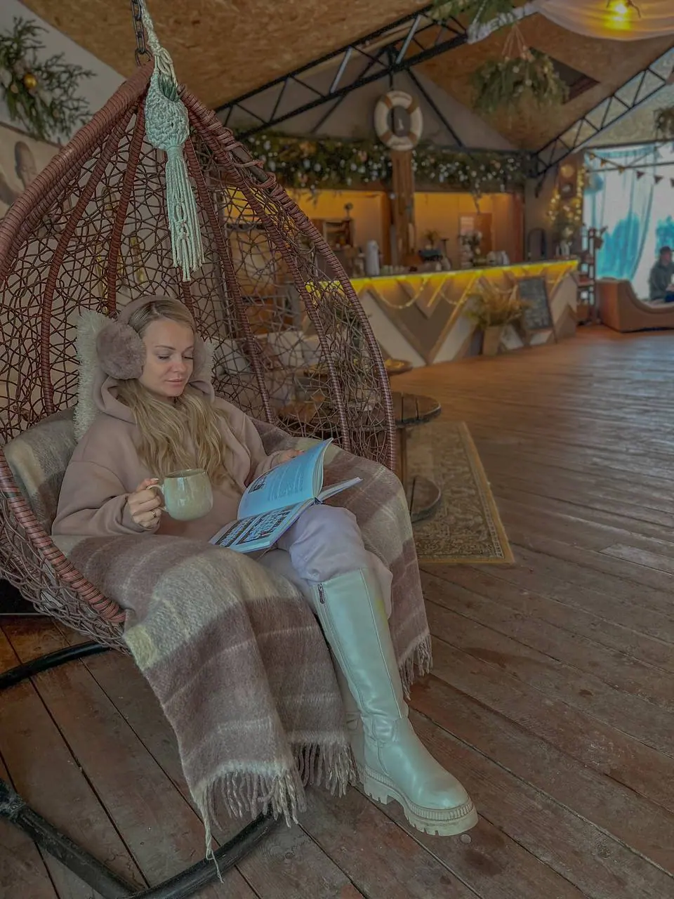 Гостья читает книгу в подвесном кресле
